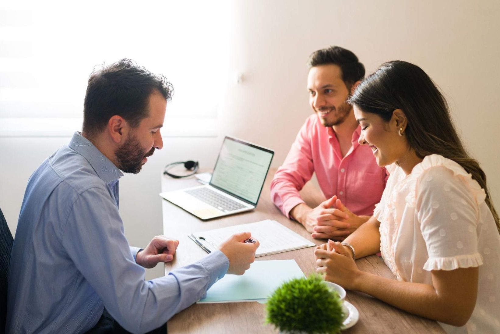 A couple at a desk with a laptop, contacting their doctor for medical advice.